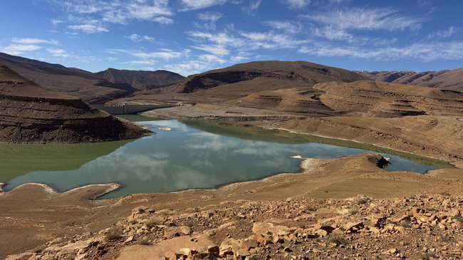 Voyage moto MM10 – Vue sur le lac de barrage bleu Lac de barrage bleu au milieu des montagnes arides du sud du Maroc