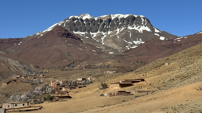 Vue sur le paysage montagneux pendant la descente depuis le point culminant de l’étape