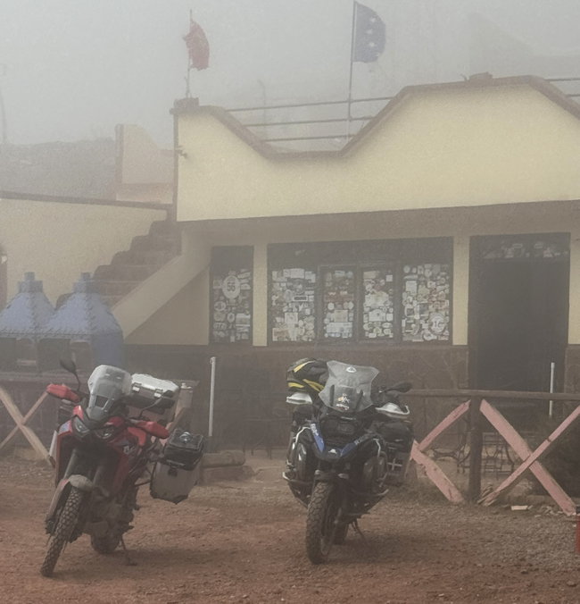 Brouillard et travaux sur la route du col Route de col dans le Haut Atlas, enveloppée d’un épais brouillard et bordée de travaux routiers