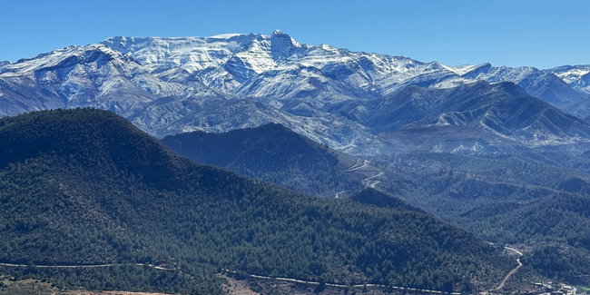 Voyage à moto au Maroc MM7 – Descente dans la vallée sur le versant sud du col de l’Atlas Descente du Haut Atlas sur une large route de montagne asphaltée, à travers un paysage de plus en plus sec et aride
