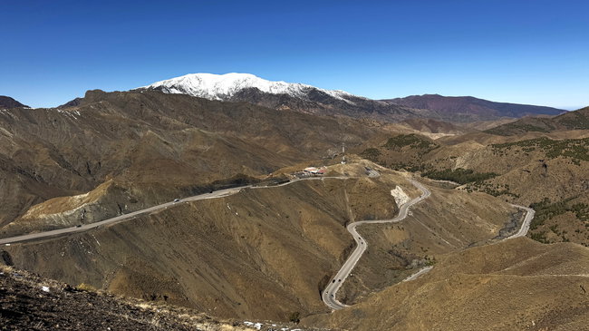 Voyage à moto au Maroc MM7 – Panorama depuis le col de l’Atlas à 2 260 mètres Point de vue au sommet du col du Haut Atlas, avec un vaste panorama sur la route sinueuse et les montagnes