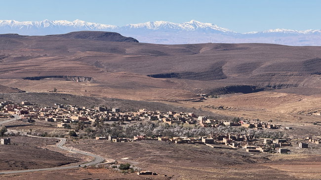 Voyage à moto au Maroc MM7 – À travers la vallée verdoyante du Drâa en direction du désert Vue sur la vallée du Drâa, avec des montagnes arides et des zones verdoyantes le long du fleuve