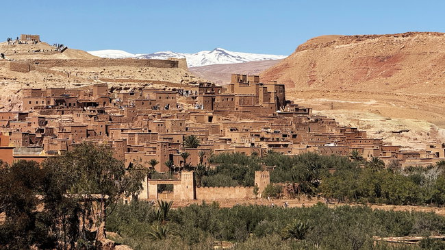 Voyage à moto au Maroc MM7 – Panorama sur les kasbahs historiques du Sud Vue sur une kasbah historique et les paysages arides environnants dans le sud du Maroc